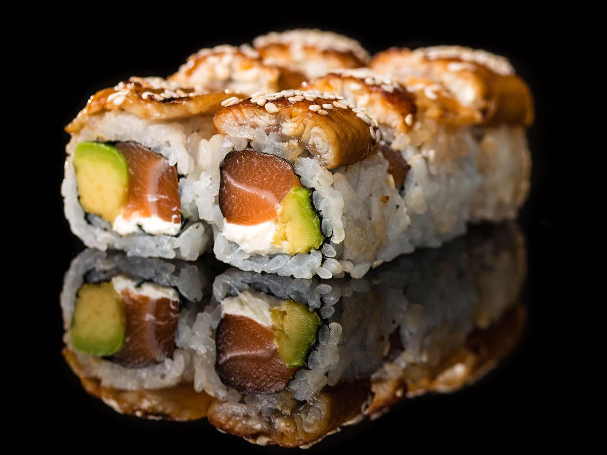 Sumosan Riyadh: salmon sushi maki rolls on a black background