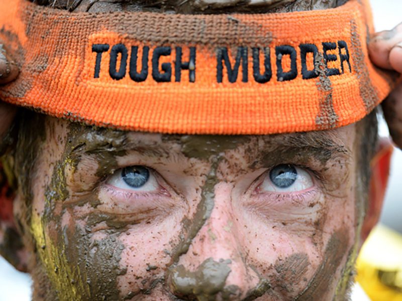 Tough Mudder RIyadh: Muddy man wearing orange Tough Mudder headband